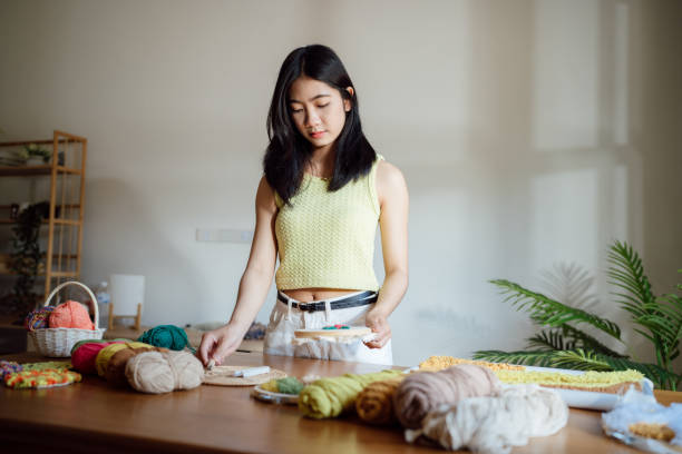 Punch needle. Asian Woman making handmade Hobby knitting in stud