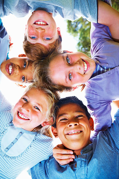 istock Group of school children forming a huddle 182171162