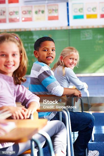 School Boy Sitting In Classroom And Looking Behind Stock Photo - Download Image Now - 10-11 Years, Adult Student, Boys