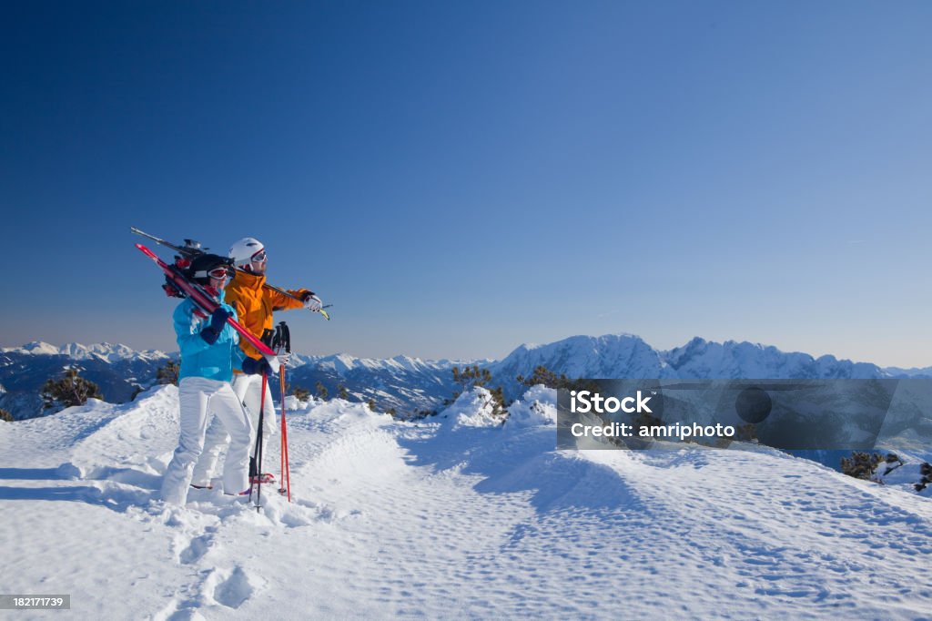 Coppia con attrezzatura da sci in montagna - Foto stock royalty-free di Moda