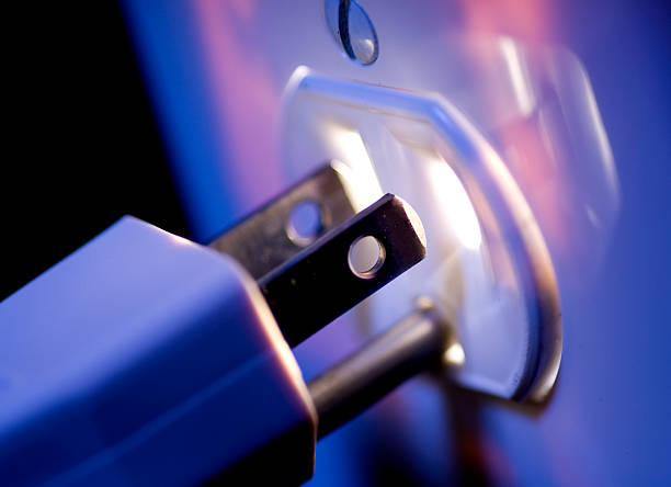 Glowing Electric Outlet and Plug A blue tinted electrical outlet glowing from within and an electrical plug. three pin plug stock pictures, royalty-free photos & images