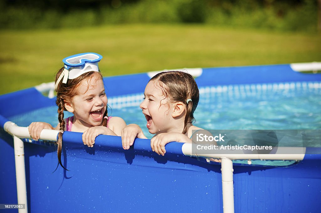 Due sorelle ridere in una piscina - Foto stock royalty-free di 2-3 anni