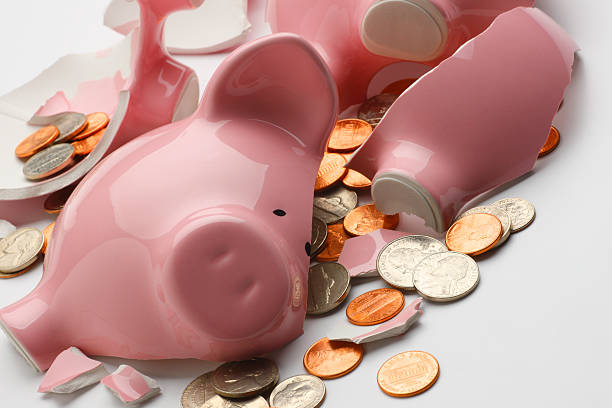 istock Coins strewn around broken pink piggy bank 182172105