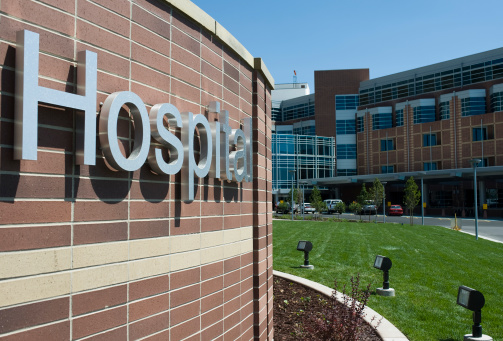 A hospital sign with a hospital in the background. **New Hospital Images Below!**