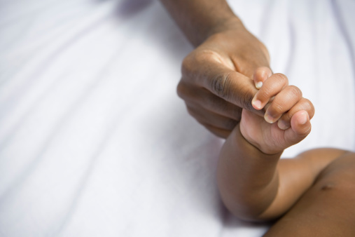African American baby holding mother's hand