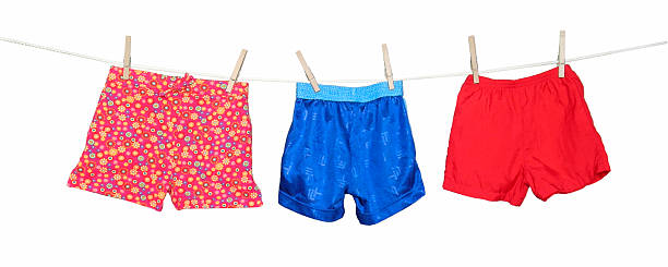 istock Colorful shorts hanging on a clothesline on white background 182173367