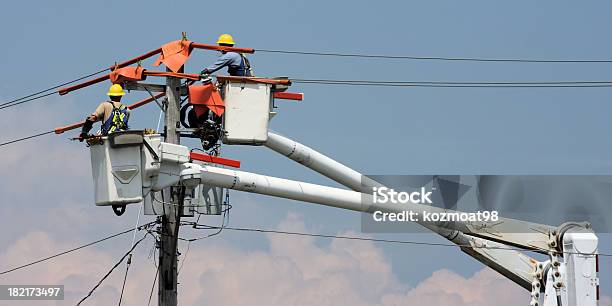 Two Workers In A Crane Repairing A Power Pole Stock Photo - Download Image Now - Power Line, Electricity, Maintenance Engineer