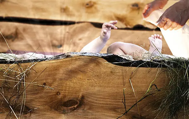 Photo of Baby Jesus lying in wooden crib.