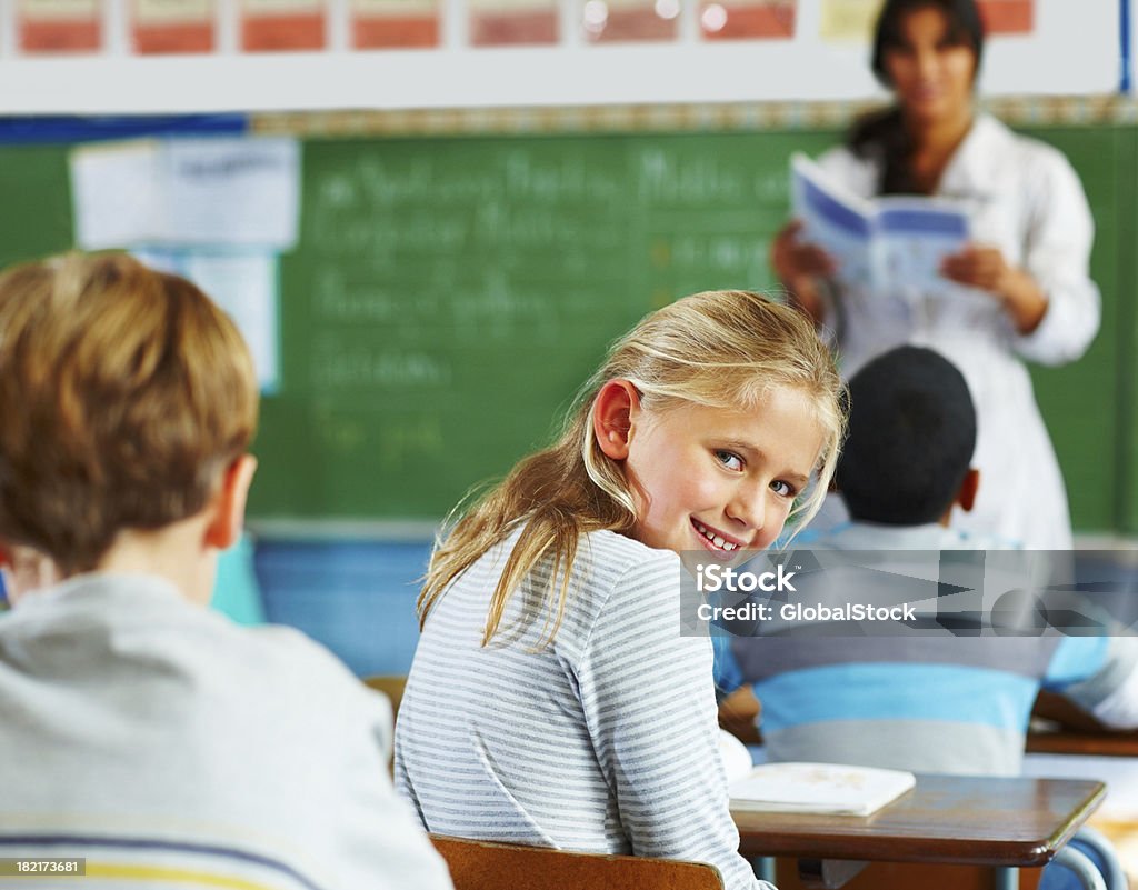 Scolara guardando behindn in classe - Foto stock royalty-free di 10-11 anni