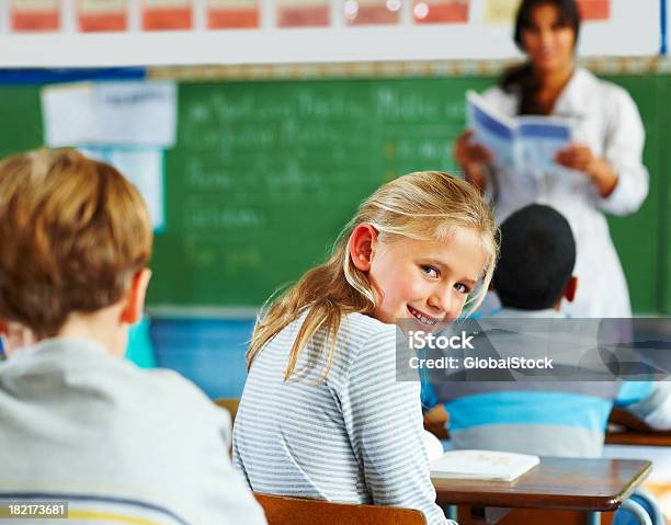 Scolara Guardando Behindn In Classe - Fotografie stock e altre immagini di 10-11 anni - 10-11 anni, Abbigliamento casual, Abilità