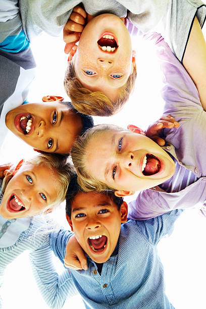 istock Low angle view of happy children huddling together 182173719