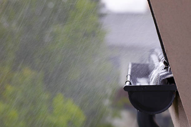 Water from the roof flowing into the rain gutter, rain streaks from long exposure