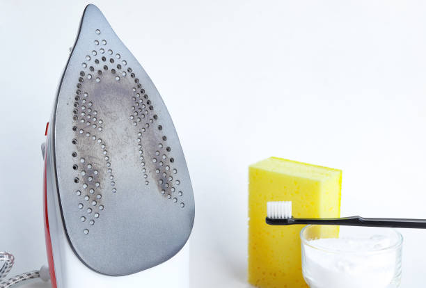 Burnt dirty electric flat iron. Clean an base surface with Baking soda, sponge. burnt iron for ironing. Cleaning the iron from carbon deposits
