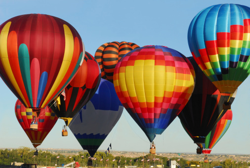 Hot Air Balloons in all their splendor (Magnificant color)  taking off and landing at the Albuquerque International Balloon Festival
