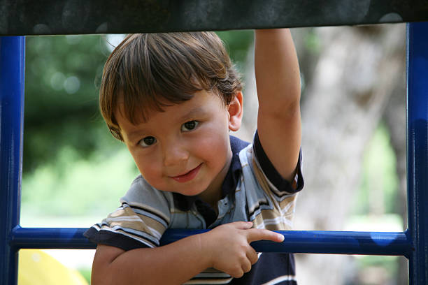 młody chłopak wspinaczka na plac zabaw - child jungle gym playground laughing zdjęcia i obrazy z banku zdjęć