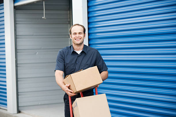 Man loading boxes for moving company at a self storage place stock photo