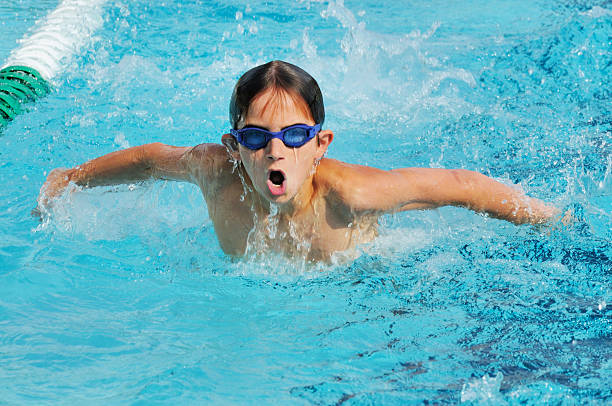 istock Young Boy Butterfly Stroke Swimmer Racing in Pool 182174428