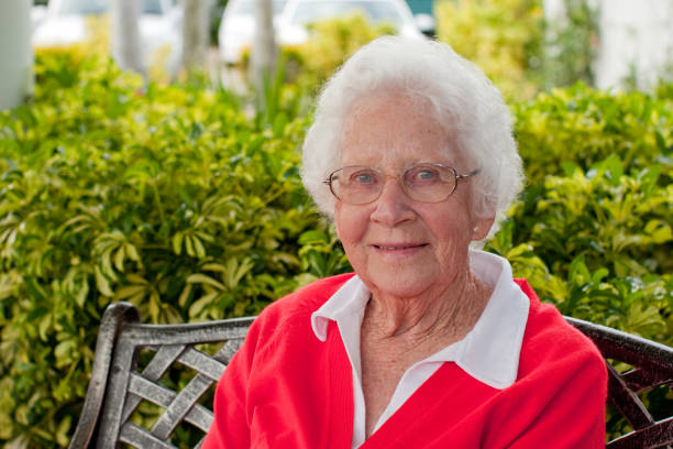 feliz mulher idosa sentada ao ar livre no jardim - great grandmother imagens e fotografias de stock