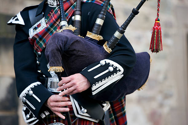 Close-up mid section of a man playing the Scottish bagpipes Close up of the hands of a Scottish bagpiper clad in a traditional scottish tartan playing the Scottish bagpipe. Royal Stewart tartan. Outdoor shot in the castle of Edinburgh, Scotland. XXXL (Canon Eos 1Ds Mark III) kilt stock pictures, royalty-free photos & images