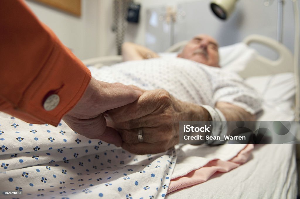 Senior Citizen - Hospital Sick This senior citizen gets comfort from his daughter as she holds his hand before surgery (that will later reveal cancer). Death Stock Photo