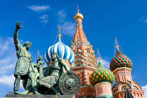 Statues in front of St Basil Cathedral with blue sky stock photo