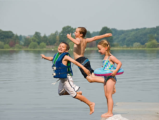 bambini saltare nel lago - life jacket little boys lake jumping foto e immagini stock