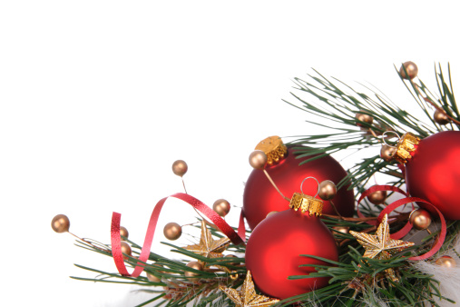 Beautiful Christmas balls, fir tree branch, ribbon and sleigh bells on snow against white background