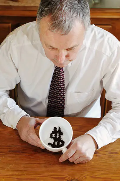 "Businessman/financier showing dollar symbol in tea-leaves, wondering about its futureFor different currencies and expressions, please see this LB"