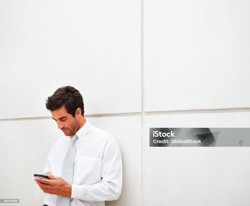Homme d'affaires de SMS sur un téléphone portable - Photo de 20-24 ans libre de droits
