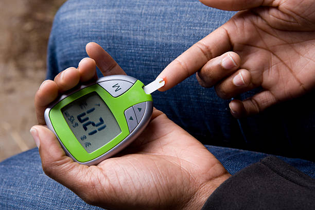 African American Woman Tests Blood Sugar stock photo