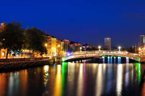 the river liffey in dublin with the haA'penny bridge at night.