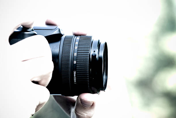 istock Photographer holding professional camera, high key, copy space 182175751