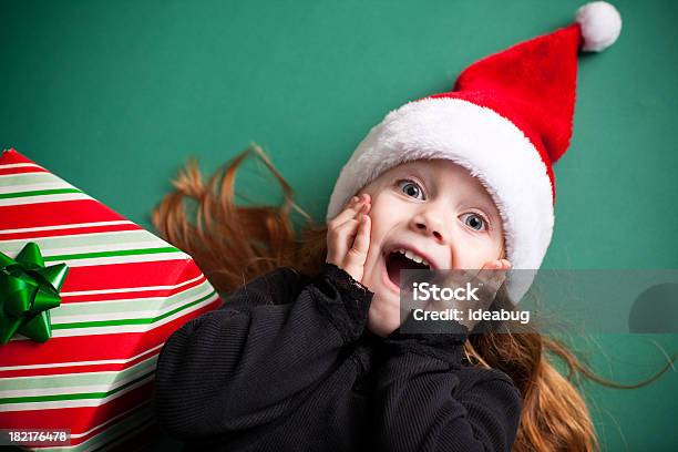 Excited Девочка В Шляпе Санта Клауса С Рождественский Подарок — стоковые фотографии и другие картинки Рождество