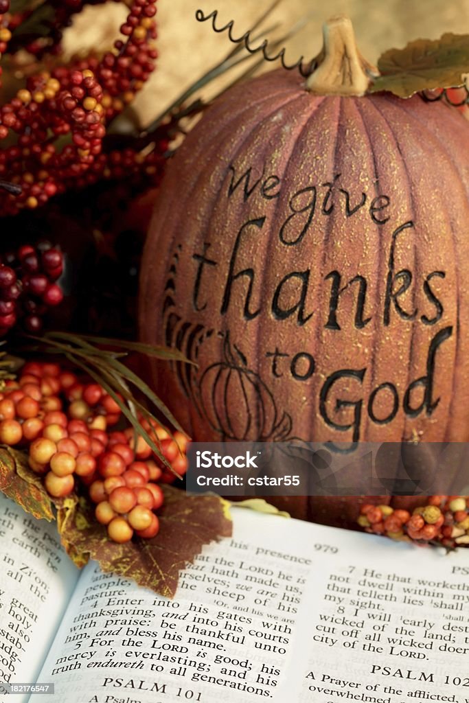 Religious : Thanksgiving Scripture with bible and pumpkin Open Bible showing Scripture from Psalm 100 with autumn berries and pumpkin inscribed with "we give thanks to God". Focus on verse 4. Vertical image would be good for Christian or religious Thanksgiving use.  Religion Stock Photo
