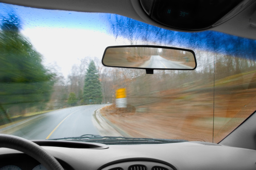 Drivers point of view in a moving vehicle on a rainy day. Motion blur.