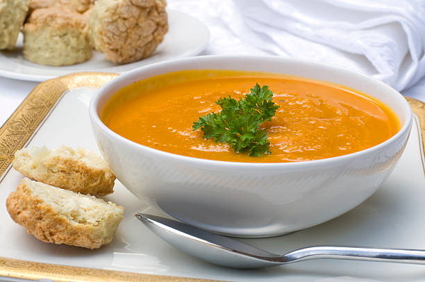 Butternut squash soup in a white bowl Butternut and carrot soup with herb scones. squash soup stock pictures, royalty-free photos & images