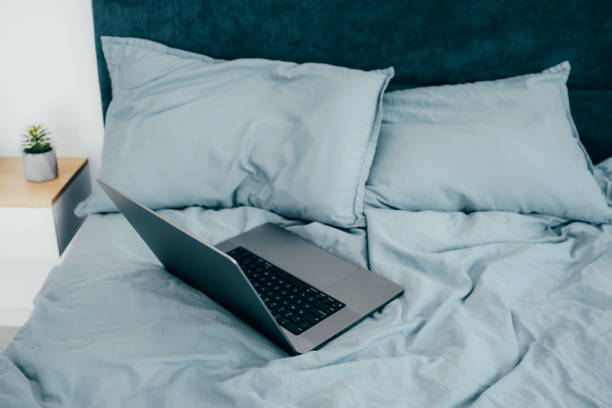 istock Laptop in the morning on a blue sheets bed. Work from home. Freelance Concept 1821766800