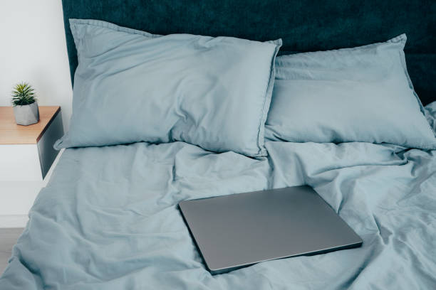 istock Laptop in the morning on a blue sheets bed. Work from home. Freelance Concept 1821767184