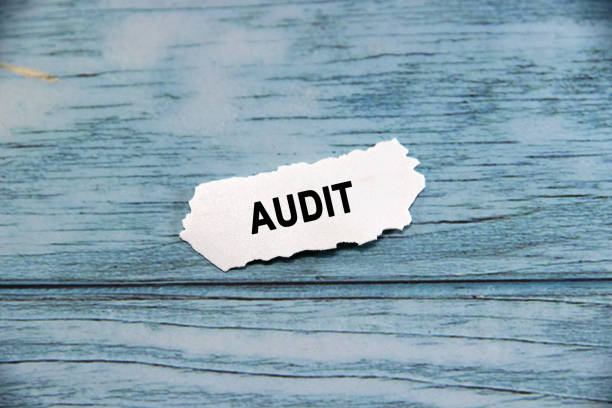 istock AUDIT text or message short word english letter on a small white paper with blue wood pattern background. 1821768439