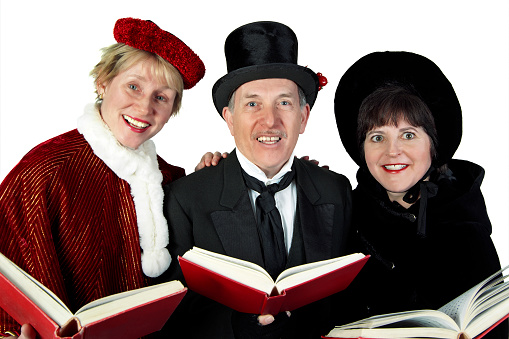 A trio of singers gather round to sing Christmas Carols during the Yuletide season.