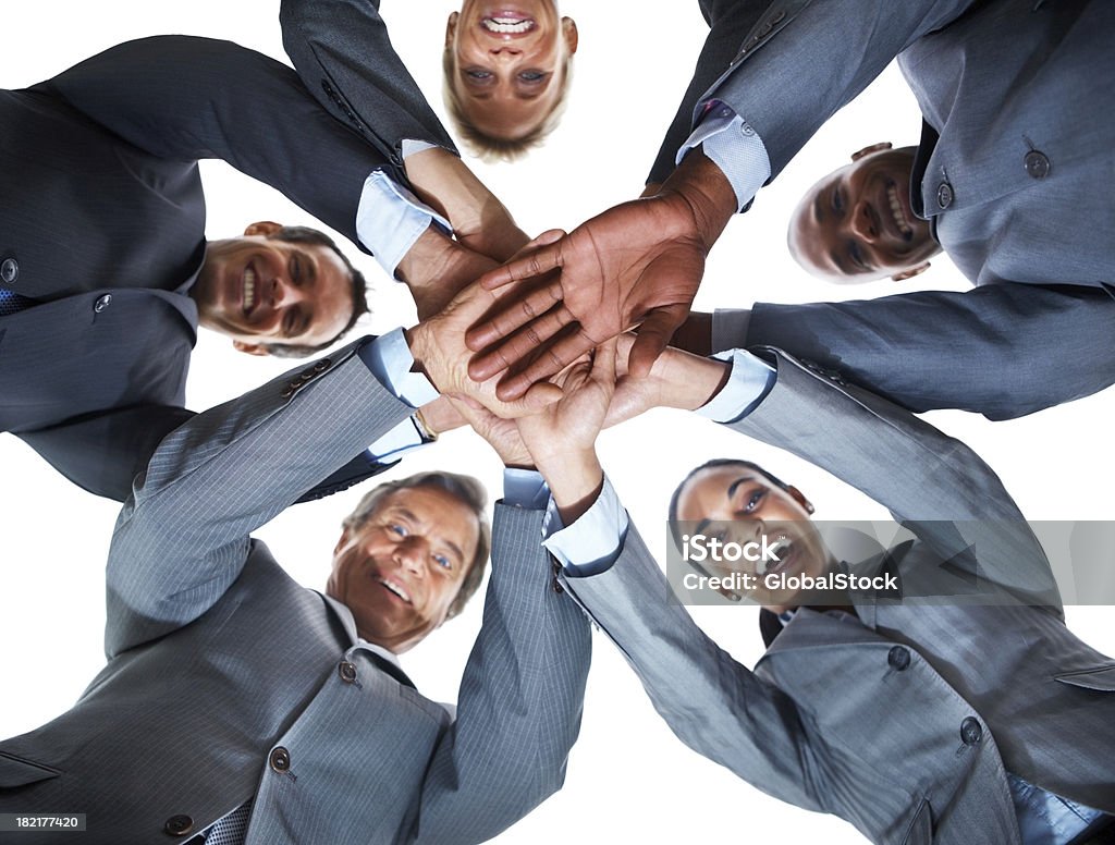 Vista de ángulo bajo de colegas de negocios mostrando unidad y sonriendo - Foto de stock de 20-24 años libre de derechos