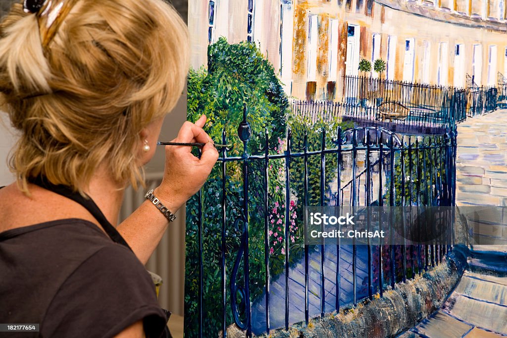 Lady artist at work painting a large acrylic artwork Acrylic Painting Stock Photo