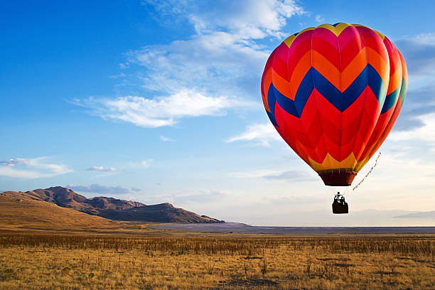 hot-air balloon rides Colorful hot-air balloon with small mountain range and lake in the backgroundEntire left hand side of image can easily be stretched to fit varying compositions and aspect ratios. See link for hot-air balloons as an example. Left side stretched about 80% motorized vehicle riding stock pictures, royalty-free photos & images