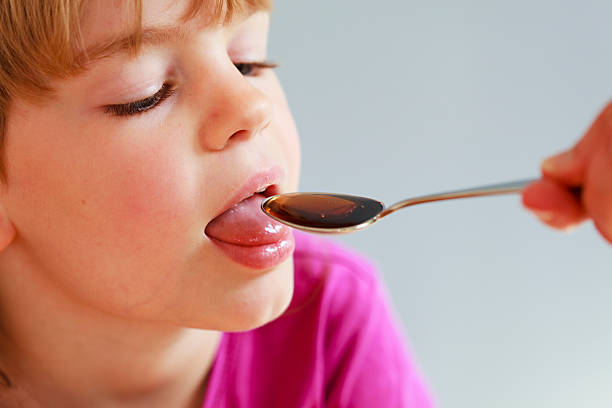 istock Young girl taking medicine from a spoon 182178087