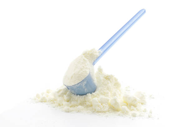 Milk Formula Pile and Scoop A pile of Baby Milk Formula with a measuring scoop, isolated on white. serving scoop stock pictures, royalty-free photos & images