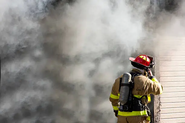 A firefighter using his radio during a fire.