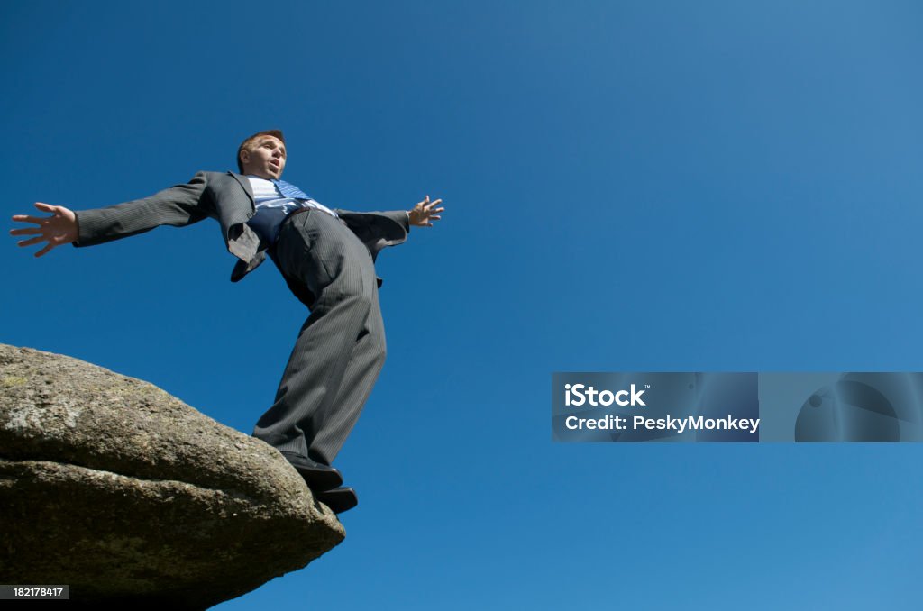 Homme d'affaires qui équilibre au bord de la falaise - Photo de Tomber libre de droits