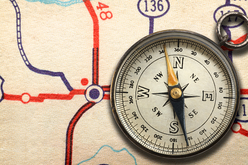 A compass sitting on a generic road map.