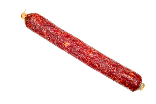 Smoked salami sausage isolated on white background. Dry raw smoked sausage close-up.