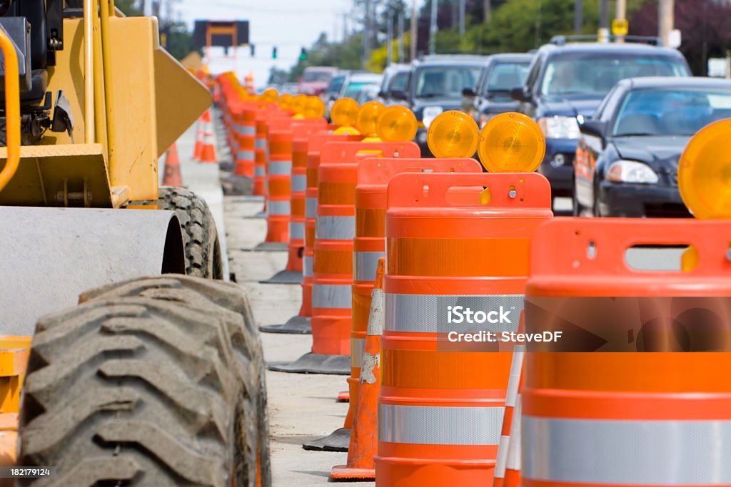 The construction led to a lot of traffic A row of bright Orange construction barriers separate construction from the busy traffic. Road Construction Stock Photo